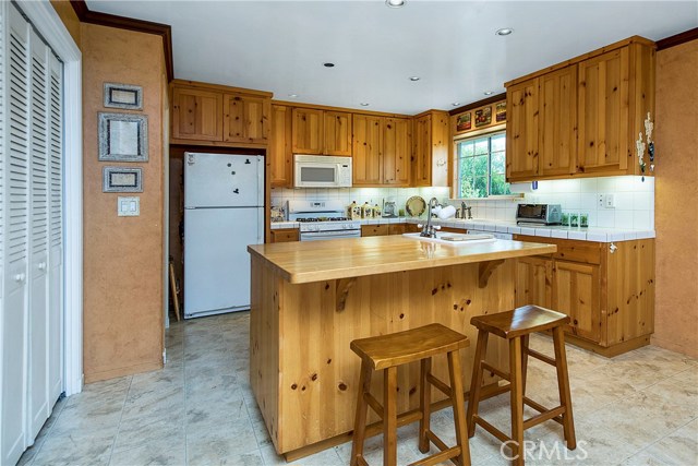 Charming & old-world rustic kitchen with butcher block island and large pantry