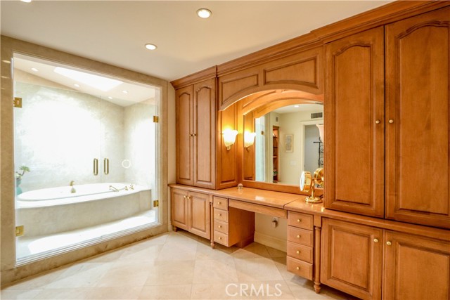 Master Bath with Crema Marfil marble/custom built-in cabinetry/walk-in closet.