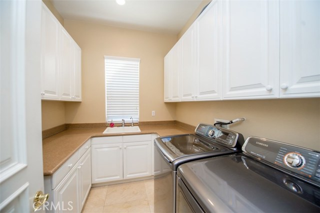 Laundry with Sink and lots of Storage Cabinets.