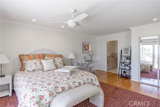 Master with neutral tones, crown moldings, gleaming wood floors, closet space galore