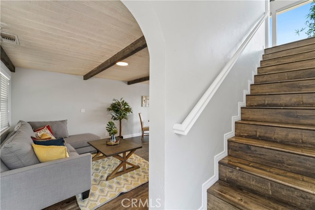 View from standing at lower level entry door into lower floor flex room and stairs to main living areas.