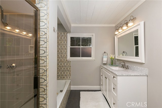 Full Guest Bathroom with shower, bathtub, and marble countertop vanity.