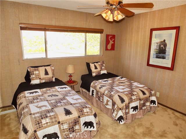 THe first bedroom is rustic with a large window looking out to the backyard