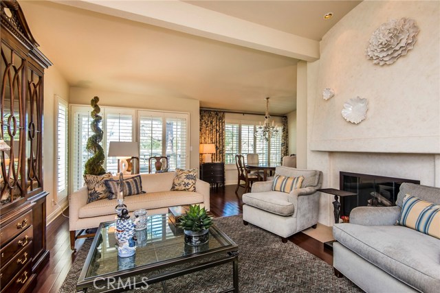 The custom fireplace is the focal point of the living room. Dark, rich wood flooring, designer paint, vaulted ceilings, recessed lighting and plantation shutters complete the space cooled by the breeze off the balcony. This floor plan is open and flowing; ideal for everyday life and entertaining!