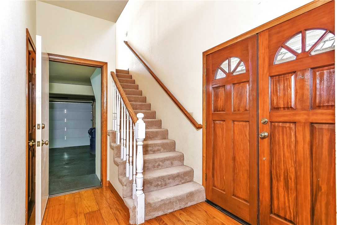 The two story entry opens to the lower level leading to the bedrooms, full bath, rear yard and garage, as well as the stairway which leads upstairs to the open living room.  There are hardwood floors and overhead windows offering a bright exposure.