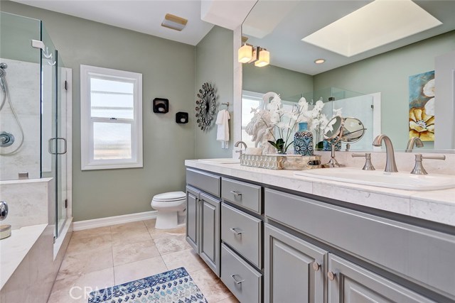 Ensuite master bathroom with newer dual sink vanity and skylight allowing for lots of light.