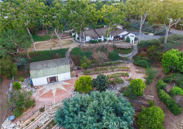 Aerial view of the property showing barn to the left and home top right - multiple pads of usable land with terraces, orchards, vineyard with room for pool or other improvements.