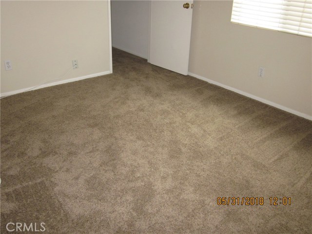 Spare room showing large walk-in closet and new carpeting.