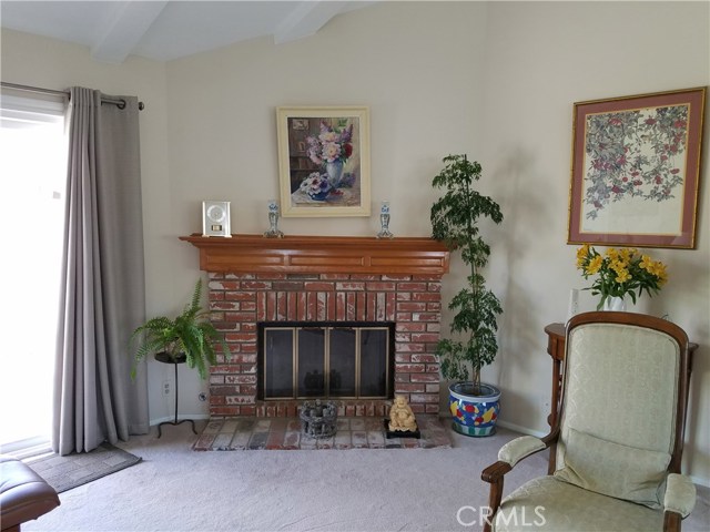 Lovely brick fireplace in living room neear sliding doors to outdoor deck