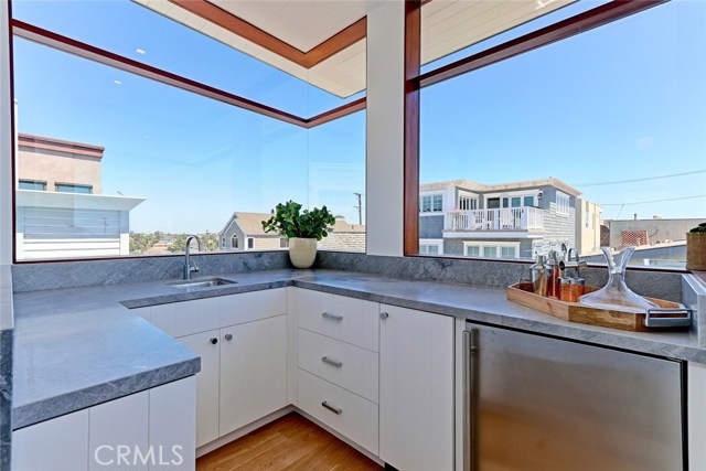 Wet bar includes hand-pounded nickel sink, paneled icemaker, beverage fridge