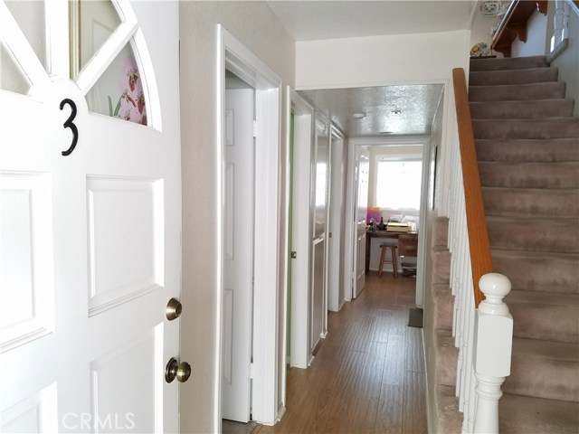 Front hallway with two bedrooms and full bathroom to the left.  The converted utility room is at the end of the hallway.