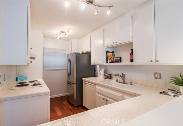 Bright kitchen with bonus stainless steel fridge, breakfast bar, and lots of storage cabinets.