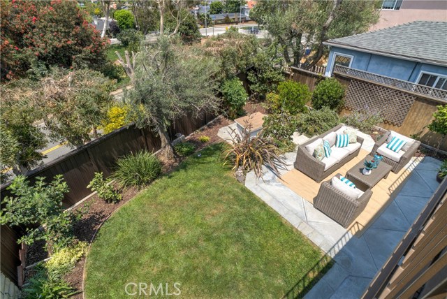 Oversized back yard with grass area and sitting area.