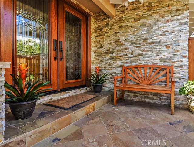 The beautifully finished raised entry to the home has custom designed craftsman style, double leaded glass doors and a wall of stacked stone.