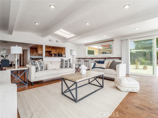 Family Room looking back to Dining Room and Kitchen; Built-In Bar Counter in distance; sliding door to Patio on right