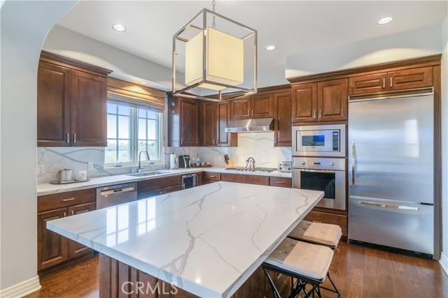 Gourmet kitchen with quartz countertops and backsplash.