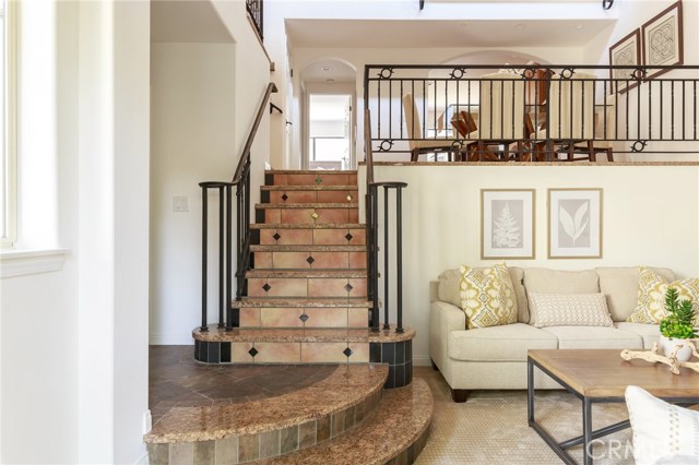 Living room with detailed staircase  and wrought iron railings