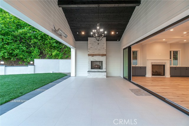 View of rustic fireplace, covered patio with built-in heating elements.  Family room on the right hand side.