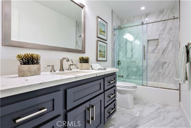 The 4th Bathroom has Porcelain Floors and Walls, Full Bath/Shower, Seamless Glass Enclosure, Large Vanity with Self-Closing Drawers and Cabinet Doors, Thick Slab Misty White Carrara Caesarstone Counter Surface and Moen or Kohler Fixtures