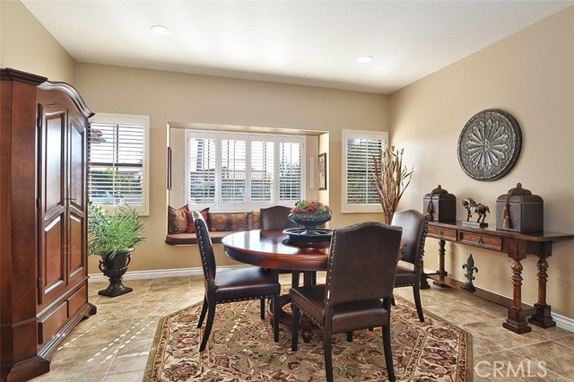 Dining area by kitchen features bay window, plantation shutters and newer flooring