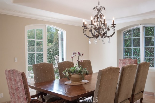 Magnificent Dining Room with Coffered Ceiling and Arch Detailed Windows and French Doors