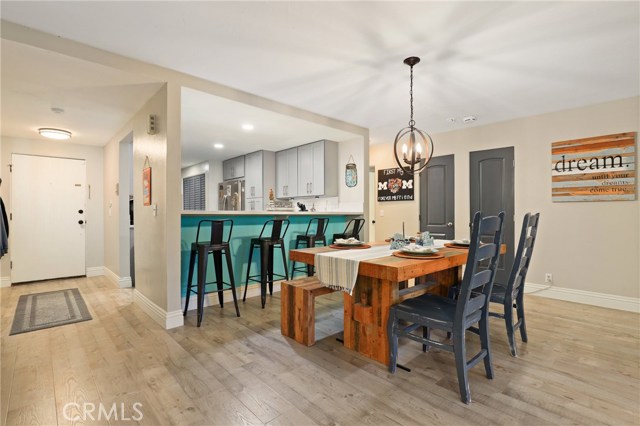 Wide shot of the entry, kitchen and dining space with gorgeous gray engineered floors throughout!