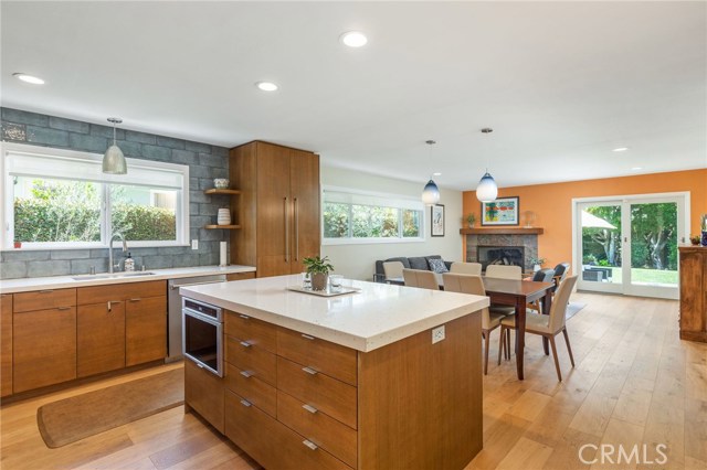 This is a large area that accommodates a dining area with custom pendant lighting and good sized family room with corner fireplace. Beautiful White Oak flooring t/o. Sliding doors lead to backyard and patio.