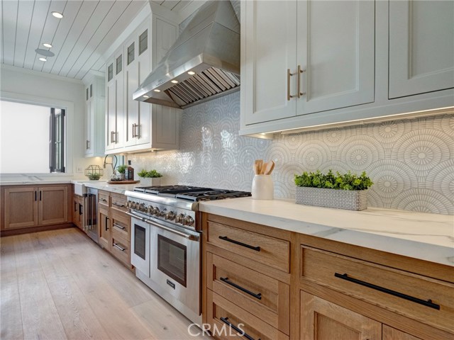 Neolith stone counters, Thermador professional series appliances, dual sinks, additional beverage fridge, Brizo faucets, breakfast counter, indoor/outdoor bar & entertainment area.