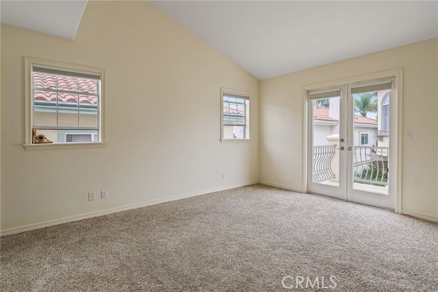 Bedroom 2 with vaulted ceilings and French Doors to deck