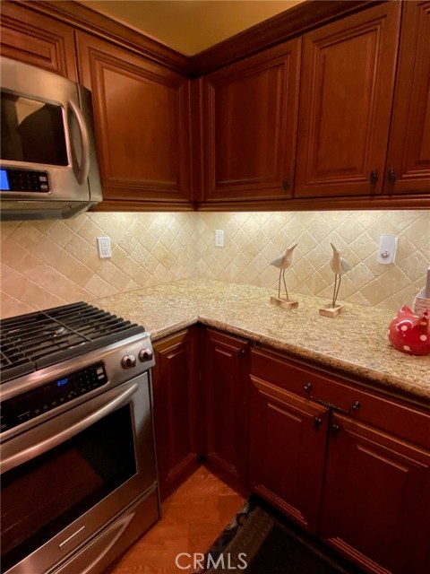 Gourmet Kitchen with Wood Cabinets. Granite Countertops with Under mount Lighting.