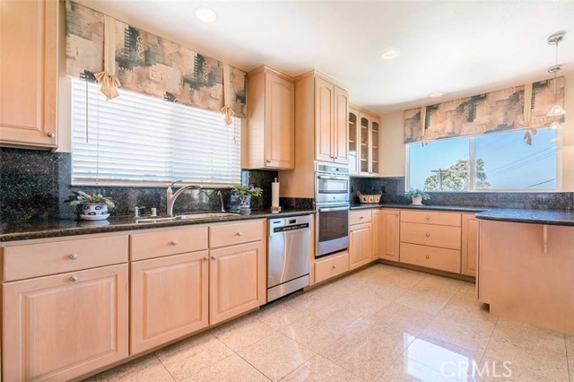 Kitchen from other direction, newer oven microwave combo, double stainless steel sink, granite counters, bar counter to the right