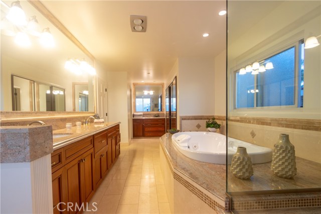 Master Bathroom bathtub with jets, double sink, makeup window, and walk in closet in the back.