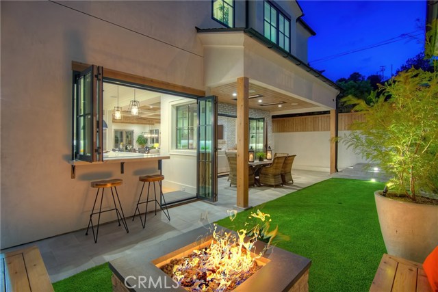 Private backyard, fire pit with seating, low maintenance artificial turf, covered patio with built-in heaters, sandblasted marble floor tiling, LaCantina door systems for the perfect indoor/outdoor experience, surround sound.