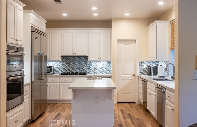 Beautifully well updated kitchen with nice countertops and glass tile backdrop