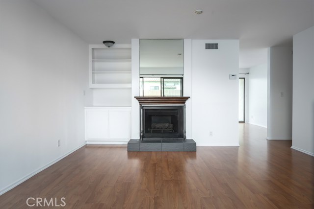 Full on view of living room with dining area on right.  Doorway goes downstairs to laundry room and garage.