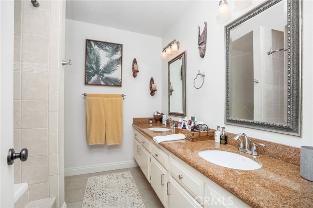 master bath has double sink counter and bath shower combo