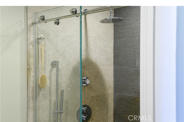 Modern shower with stone enclosure and frameless sliding-glass door