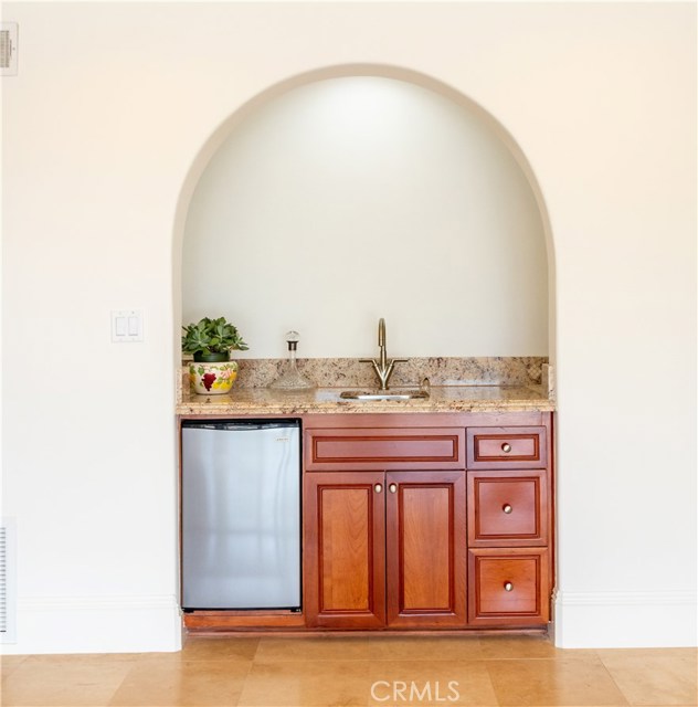 Family room wet bar with sink and refrigerator