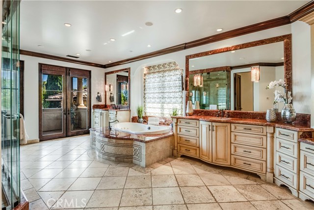 Luxurious master bath with dual sinks steam shower, spa tub and lighted vanity area.