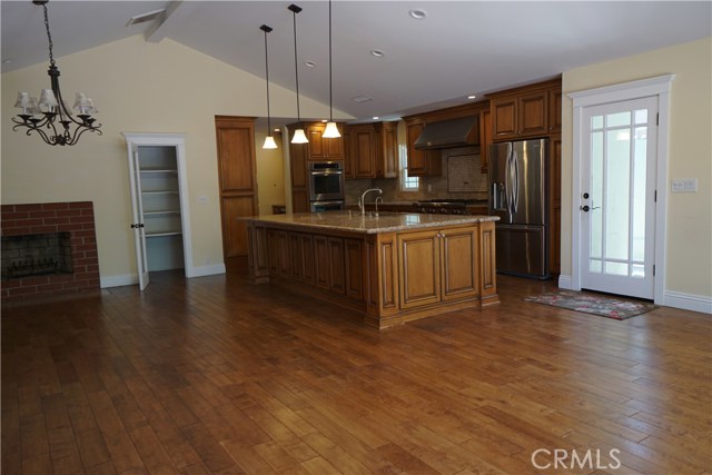 Concrete patio outside kitchen for ping pong table, storage, or play area.  Outside fireplace.