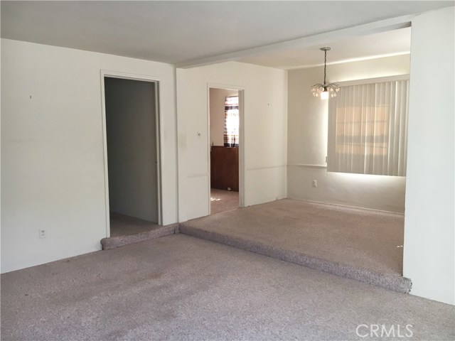 looking from the living room to the dining room and the kitchen door
