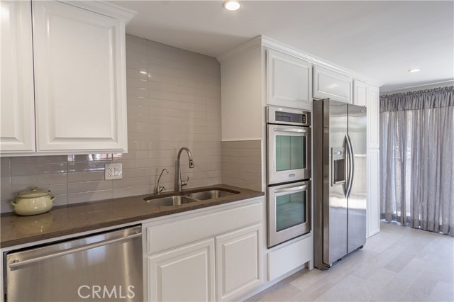 Double stainless sink and tan subway wall tiles