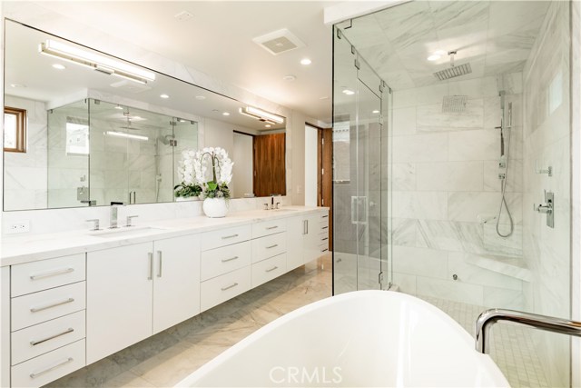 Master Bath with long Pullman, soaking tub and shower, adorned with Calcutta Bella marble