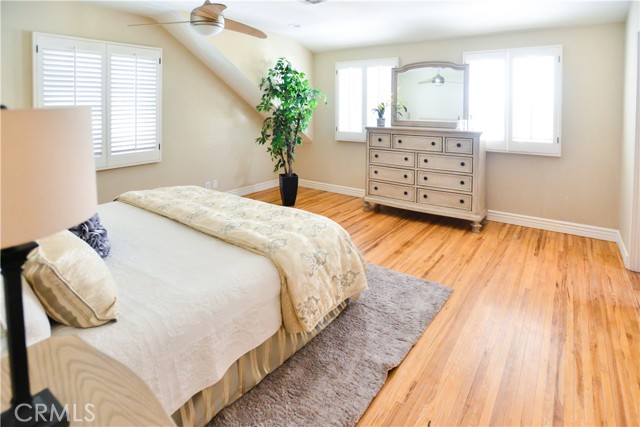 Master bedroom with pecan wood floors and ceiling fan.