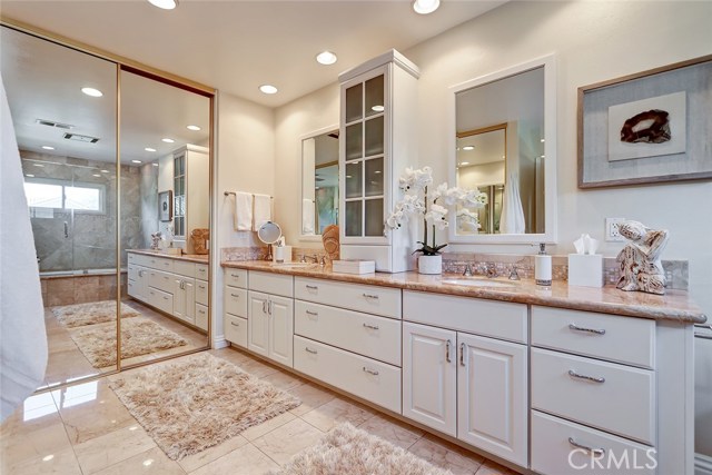 Expansive remodeled master bathroom with dual sink countertops and walk-in closet.