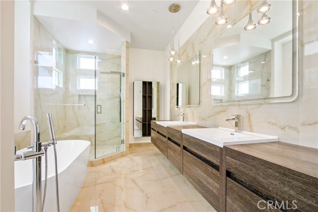 Extra-ordinary Master Bathroom with free standing tub, huge walk in shower with frameless glass doors and wide floating vanity.