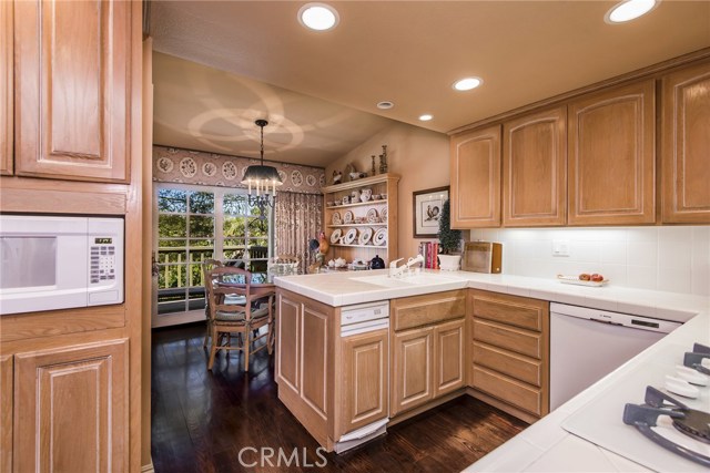 The kitchen is bursting with natural light and entirely functional with clean, white tile counters, real wood cabinets and ample storage. Scenic nature views from the kitchen sink plus a charming breakfast nook with French doors to the balcony. Imagine peaceful mornings in this gorgeous home!