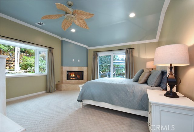 Master bedroom with fireplace and access to backyard patio