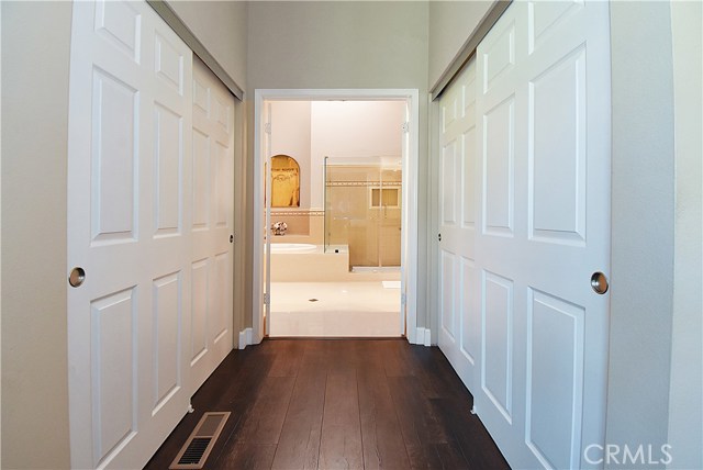 Master entry to luxurious bathroom past dual walk-in closets