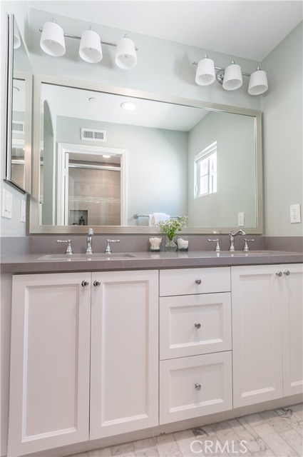 The master bath includes a vanity with dual sinks, quartz countertops and carrara marble tile.